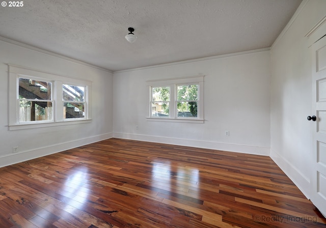 empty room featuring hardwood / wood-style floors, a textured ceiling, ornamental molding, and baseboards