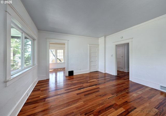 spare room with wood finished floors, baseboards, and ornamental molding