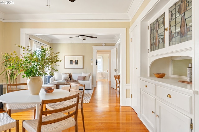 dining room featuring ceiling fan, ornamental molding, and light hardwood / wood-style flooring