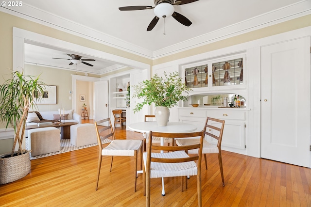 dining area with crown molding, ceiling fan, and light wood-type flooring