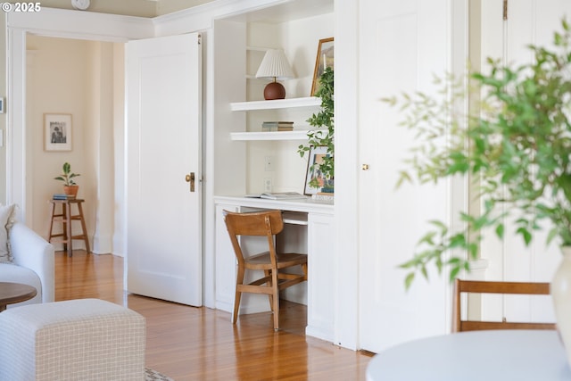 interior space with built in desk and light wood-type flooring