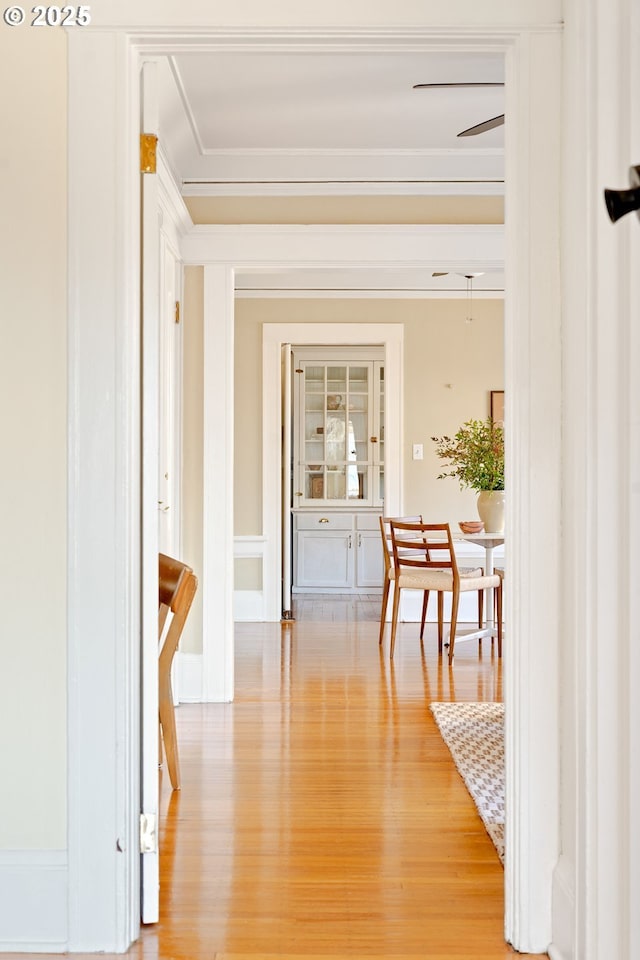 hall with light hardwood / wood-style flooring and ornamental molding