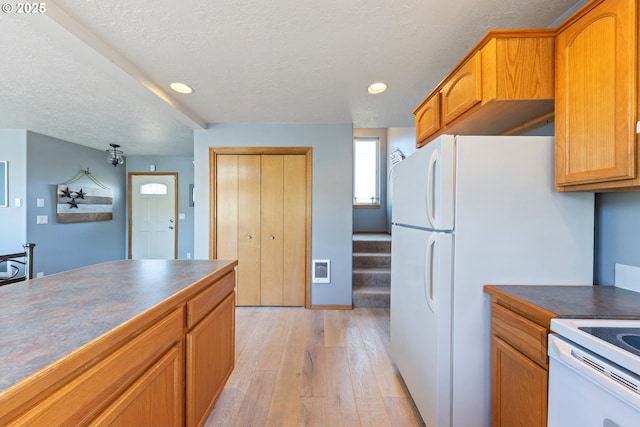 33645 Resort Dr, Pacific City, OR 97135 - kitchen featuring dark countertops, light wood-style floors, recessed lighting, a textured ceiling, and brown cabinets