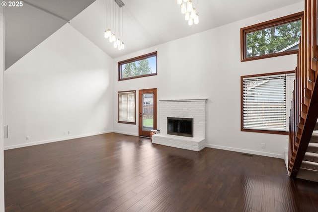 unfurnished living room with dark wood finished floors, a notable chandelier, and plenty of natural light