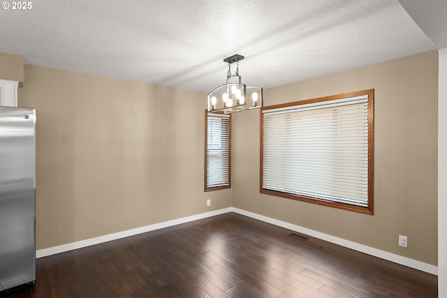 unfurnished dining area with dark wood finished floors, visible vents, and baseboards