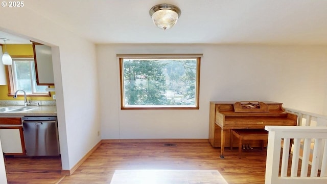 interior space featuring visible vents, light wood-style flooring, and baseboards