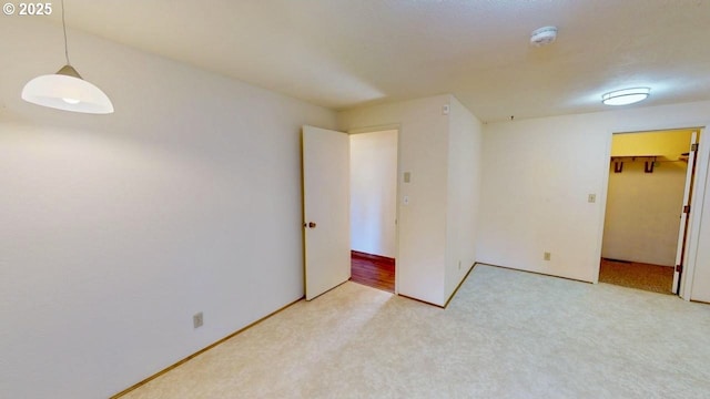 spare room featuring light colored carpet