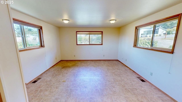 empty room featuring baseboards and visible vents