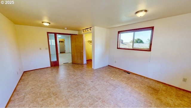 spare room with visible vents, baseboards, and french doors