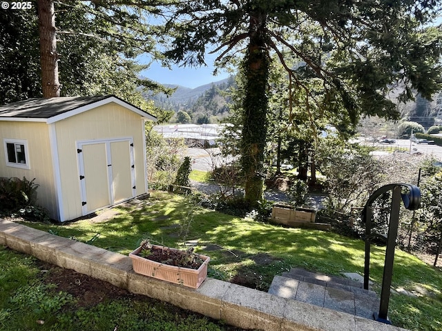 view of yard with a mountain view, a storage shed, an outdoor structure, and a garden