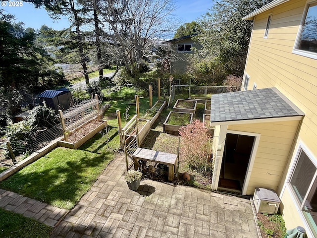 view of yard featuring a patio, a vegetable garden, and fence