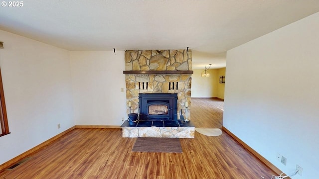 unfurnished living room with visible vents, baseboards, and wood finished floors