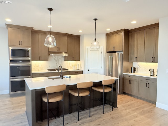 8015 NE 172nd Ave, Vancouver, WA 98682 - kitchen featuring stainless steel appliances, under cabinet range hood, light wood finished floors, decorative backsplash, and recessed lighting