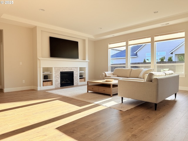 8015 NE 172nd Ave, Vancouver, WA 98682 - living room with light wood-type flooring, a stone fireplace, baseboards, and healthy amount of natural light