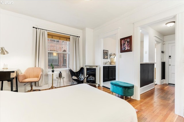 bedroom with wood-type flooring and connected bathroom