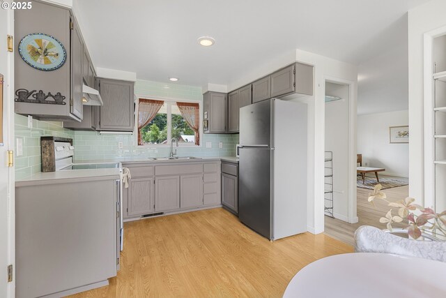 91161 N Miller St, Eugene, OR 97408 - kitchen with freestanding refrigerator, gray cabinetry, light wood-style flooring, electric stove, and custom range hood