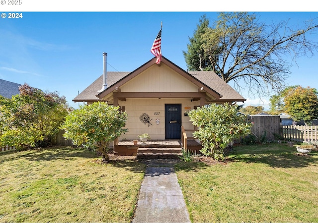 view of front of house with covered porch, fence, and a front yard