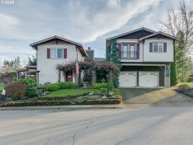 craftsman-style home featuring a garage, stairway, and aphalt driveway