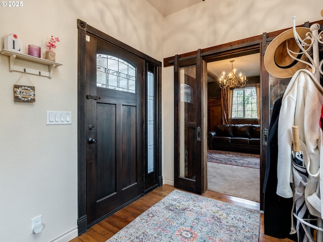 entryway featuring dark wood-type flooring and a notable chandelier