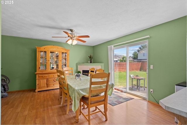 112 NE 11th St, Hermiston, OR 97838 - dining area featuring light wood-style flooring, a ceiling fan, baseboards, and a textured ceiling