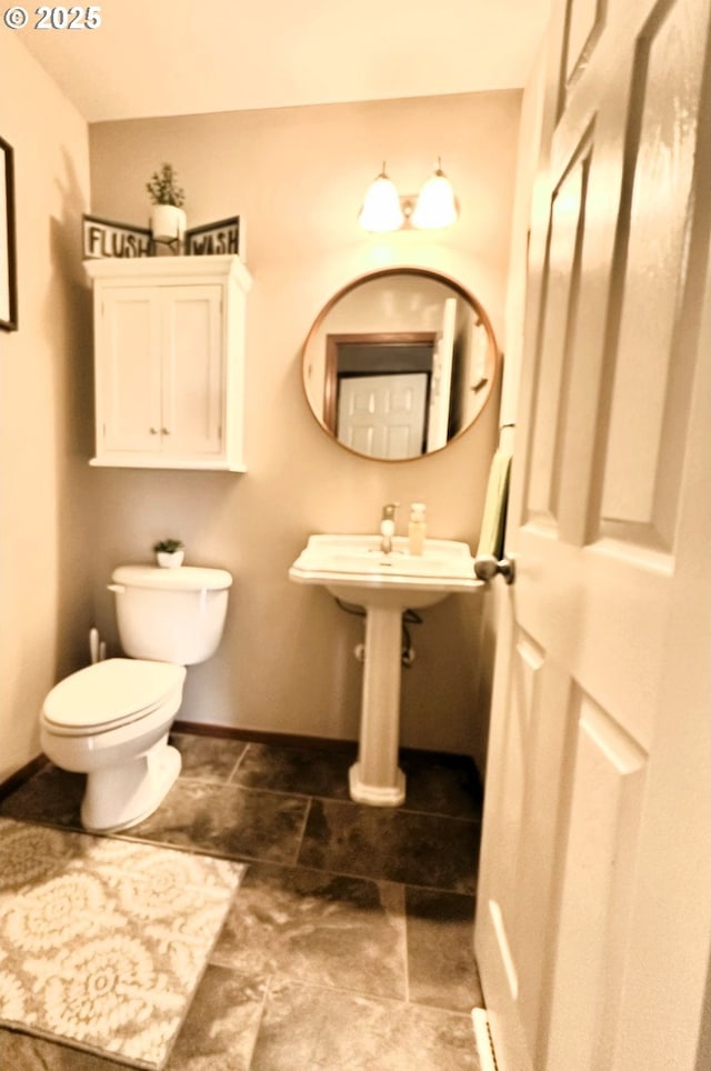 bathroom featuring toilet and baseboards