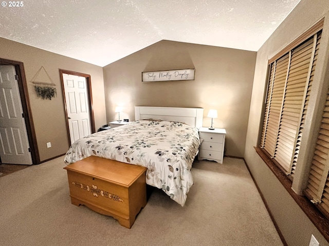 bedroom featuring light carpet, lofted ceiling, a textured ceiling, a closet, and baseboards