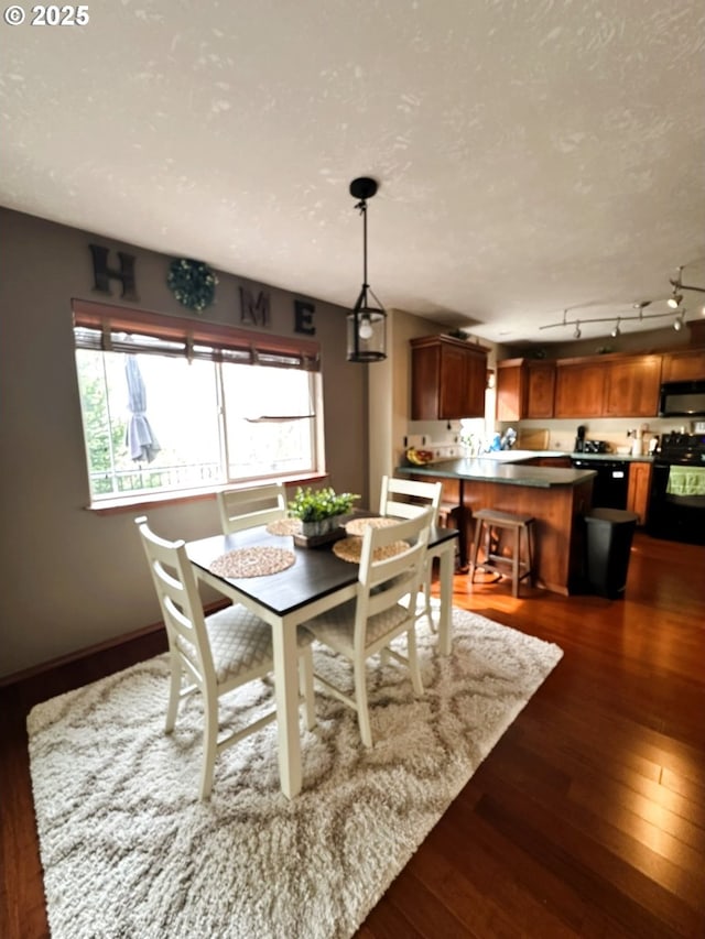 dining area featuring dark wood-style floors, a textured ceiling, and baseboards