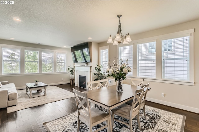 12967 SW River Terrace Blvd, Beaverton, OR 97007 - dining area featuring a chandelier, baseboards, a tile fireplace, recessed lighting, and dark wood-style flooring