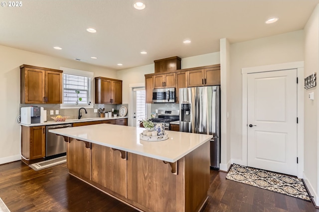 12967 SW River Terrace Blvd, Beaverton, OR 97007 - kitchen with stainless steel appliances, a sink, dark wood-style flooring, brown cabinets, and recessed lighting