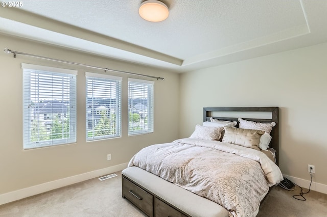 12967 SW River Terrace Blvd, Beaverton, OR 97007 - bedroom with light colored carpet, baseboards, multiple windows, and a textured ceiling