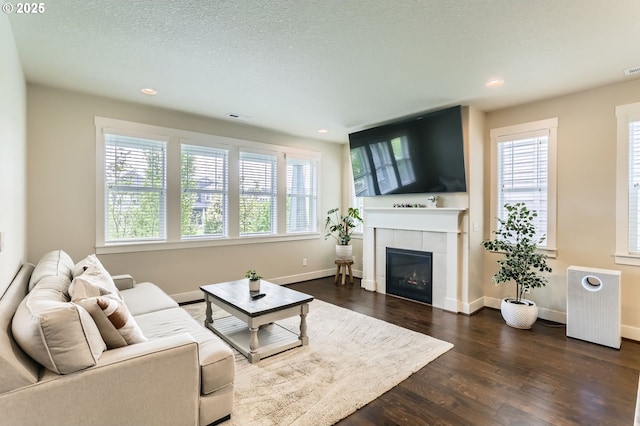 12967 SW River Terrace Blvd, Beaverton, OR 97007 - living room with radiator, dark wood-style floors, recessed lighting, a tile fireplace, and baseboards