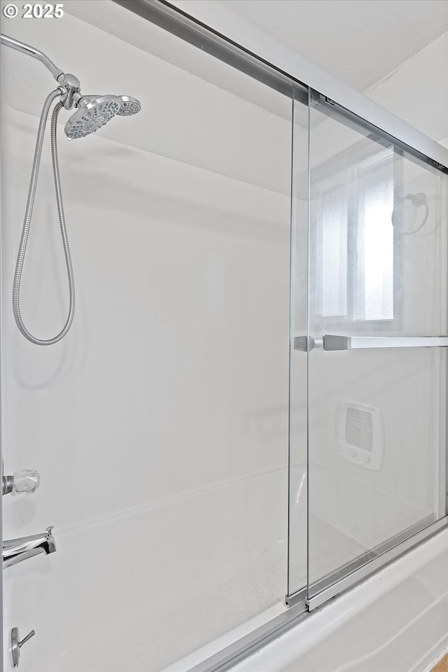 bathroom featuring bath / shower combo with glass door