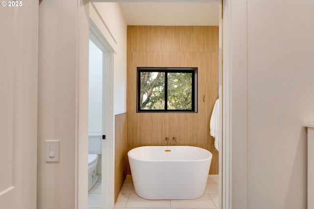 bathroom featuring toilet, a bathtub, and tile patterned floors