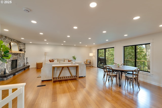 dining room with a fireplace and light hardwood / wood-style floors