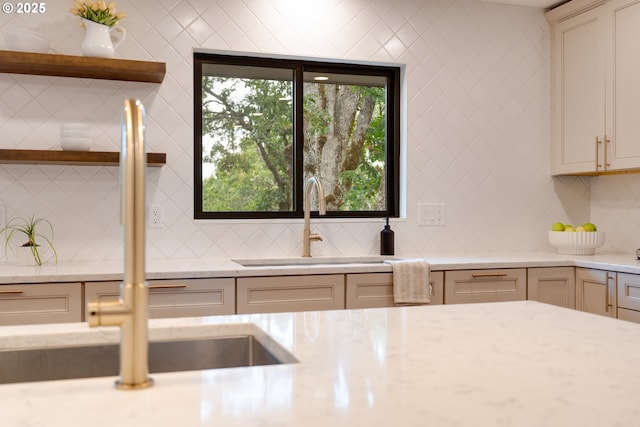 kitchen with sink, cream cabinetry, backsplash, and a healthy amount of sunlight