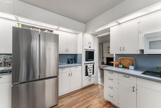185 W Oriole Dr, Roseburg, OR 97471 - kitchen featuring white appliances, light wood-style floors, white cabinetry, and light countertops