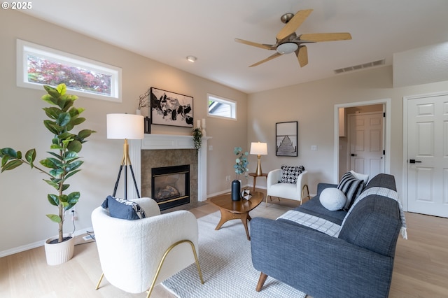 10134 SE 54th Ct, Milwaukie, OR 97222 - living area with a tiled fireplace, a ceiling fan, light wood finished floors, and baseboards