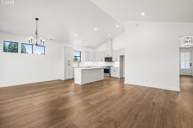 88109 Jameson Way, Veneta, OR 97487 - unfurnished living room with a chandelier, light wood-type flooring, recessed lighting, high vaulted ceiling, and baseboards