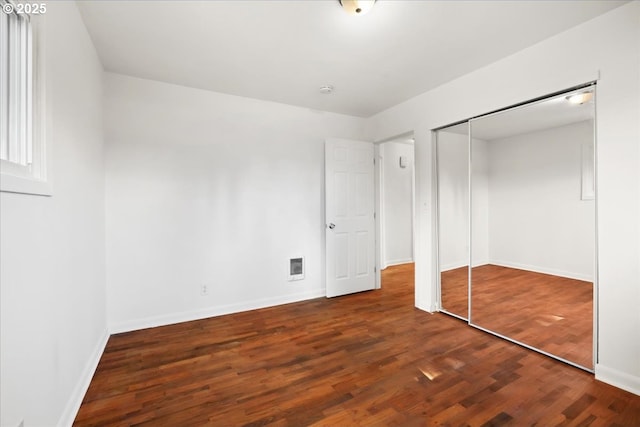 unfurnished bedroom featuring visible vents, baseboards, and wood finished floors