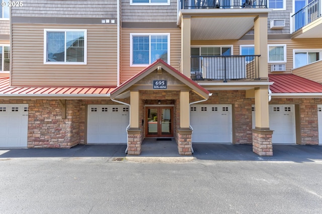 695 NW Falling Waters Ln Unit 304, Portland, OR 97229 - townhome / multi-family property featuring french doors, stone siding, metal roof, and an attached garage