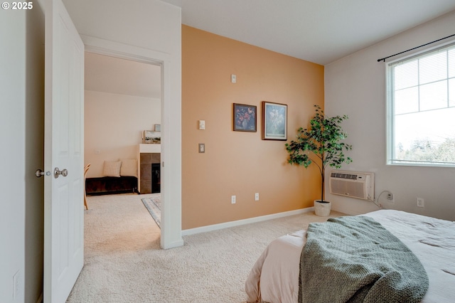 695 NW Falling Waters Ln Unit 304, Portland, OR 97229 - bedroom with an AC wall unit, carpet floors, a fireplace, and baseboards