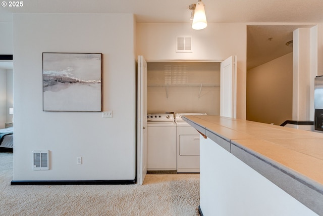 695 NW Falling Waters Ln Unit 304, Portland, OR 97229 - laundry room with washing machine and clothes dryer and light carpet