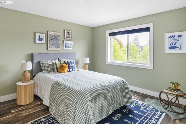 bedroom with baseboards and dark wood-type flooring