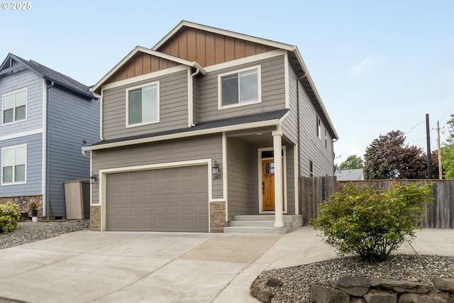craftsman house with fence, stone siding, board and batten siding, concrete driveway, and an attached garage