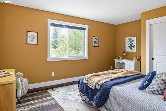 bedroom with baseboards and dark wood-style flooring