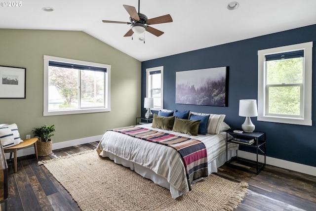 bedroom with baseboards, vaulted ceiling, multiple windows, and wood finished floors
