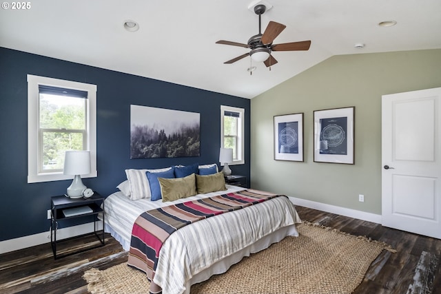 bedroom featuring baseboards, multiple windows, vaulted ceiling, and wood finished floors
