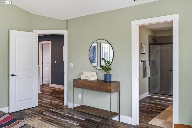 bedroom featuring baseboards, wood finished floors, and ensuite bath