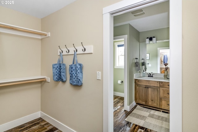 bathroom with baseboards, visible vents, wood finished floors, and vanity