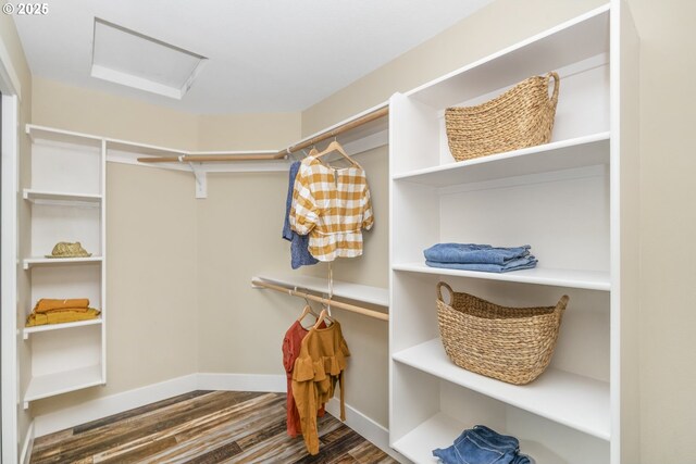 walk in closet with wood finished floors and attic access